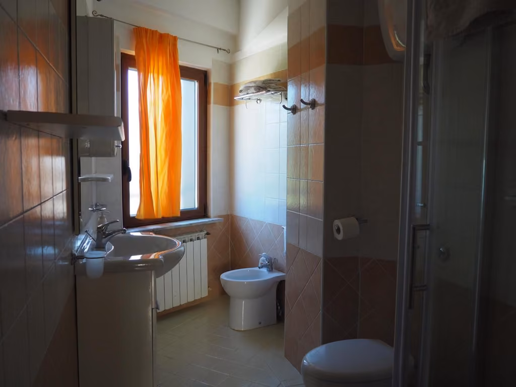 Bagno con lavandino, WC e finestra dell'appartamento I Narcisi a Roccaraso