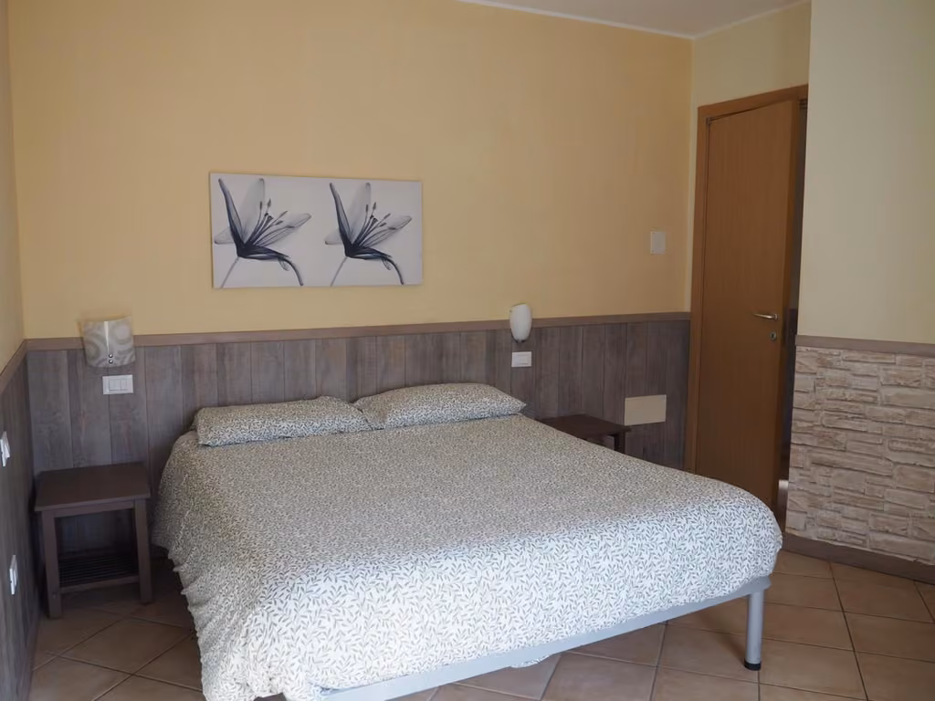 Camera da letto con letto matrimoniale e due quadri sul muro dell'appartamento I Narcisi a Roccaraso